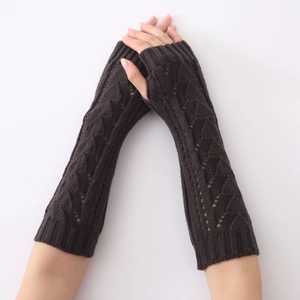 Détail de mitaines en tricot marron foncé avec motif triangulaire ajouré d'hiver