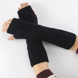 Détail de mitaines noires en maille torsadée avec poignets côtelés et texture tricotée