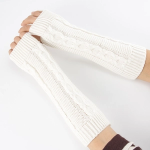 Détail de mitaines en tricot torsadé blanc crème montrant des chauffe-bras d'hiver