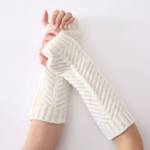 Close-up of cream knit arm warmer featuring a detailed herringbone crochet pattern