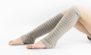 Detail of light beige knit leg warmer with wave crochet pattern and over-the-knee design