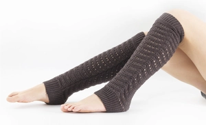 Detailed close-up of dark coffee knit leg warmers with wavy cutout crochet texture