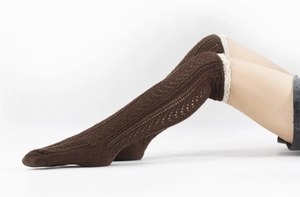 Detailed knit texture of dark brown leg warmers with delicate cream lace trim