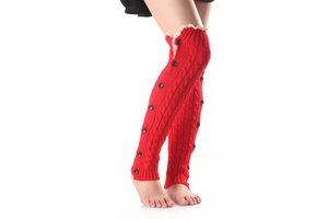 Detail view of red cable knit leg warmers with black buttons and white lace trim
