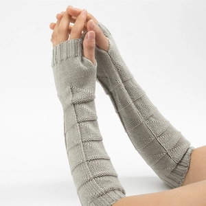 Close-up of light gray knitted fingerless gloves with a triangle geometric textured pattern