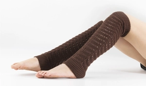 Close-up of deep brown knitted leg warmers with delicate wavy hollow-out stitch patterns