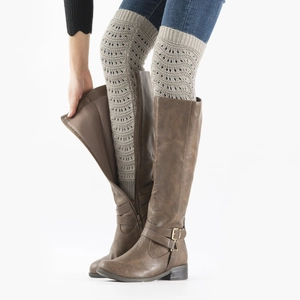 Detail of grey knit leg warmers with hollow wave pattern worn over brown high boots