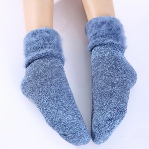 Close-up of winter thermal socks featuring thick knit texture and blue faux fur cuffs