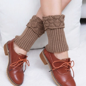 Detail of brown knit leg warmers with scallop edges and hollow patterns worn with leather oxfords