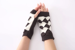 Detail of chunky knit fingerless gloves with brown and white color-block patterns