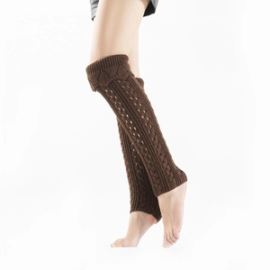 Close-up of dark brown hollow-out knitted leg warmers with ribbed cuff details