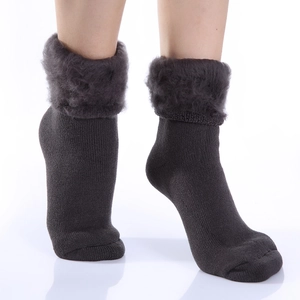 Close-up of deep brown winter socks with thick faux fur lining and knitted texture