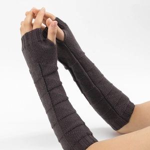 Detail of dark brown knitted fingerless gloves with geometric texture and ribbed cuffs