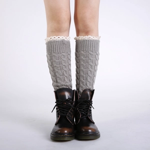 Détail de jambières grises en tricot torsadé avec dentelle et bottes vintage