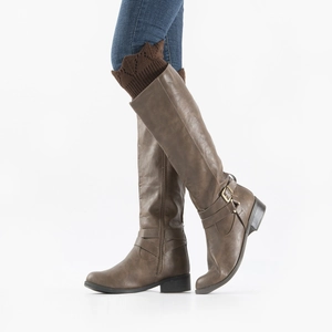 Detail of dark brown knit leg warmers worn over knee-high boots with denim jeans