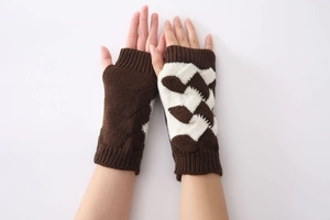 Detailed texture of thick knit fingerless gloves in brown and beige contrast colors