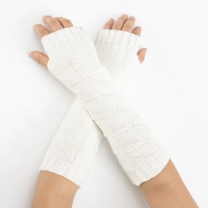 Detail of white knit fingerless gloves showing geometric diamond patterns and ribbed cuffs