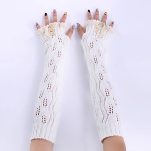 Détail de mitaines en tricot avec bordure en dentelle et boutons en bois
