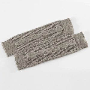 Détail de mitaines grises en tricot torsadé montrant la texture et les poignets