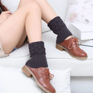 Detail of charcoal grey twist knit boot cuffs with ribbed trim on female legs