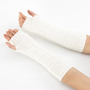 Close-up of white knitted fingerless gloves showing checkered texture and ribbed cuffs