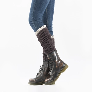 Detail of dark brown knit leg warmer with cream lace trim worn over blue jeans