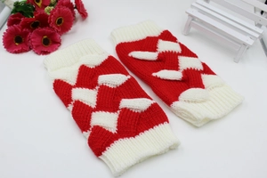 Macro shot of thick red and white knit arm warmers with textured cable patterns