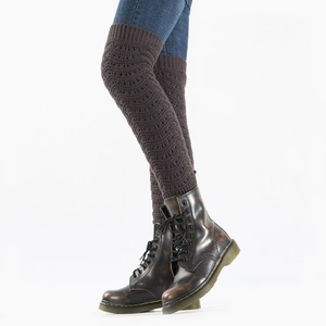 Close-up of dark brown hollow-out knit leg warmers showing intricate patterns and ribbing