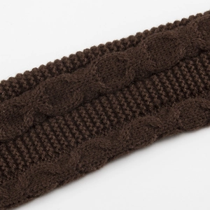 Vue macro des gants sans doigts en tricot torsadé marron foncé et chauffe-poignets
