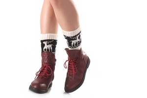 Détail de jambières en tricot avec motifs de renne et bottines à lacets rouge foncé