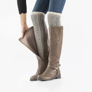 Close-up of dark grey knitted leg warmers with delicate mesh pattern and lace trim