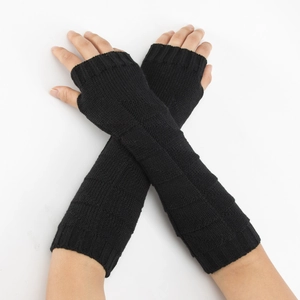 Detail of long black knitted fingerless gloves with elegant diamond pattern texture