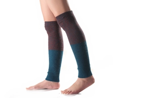 Detail of knit leg warmers showing bicolor rib texture in crimson and bright blue