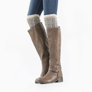 Detail of grey hollow-out knit leg warmers with lace trim over brown leather boots