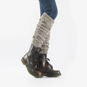 Detail of grey hollow knit leg warmers with chunky cable pattern over leather boots