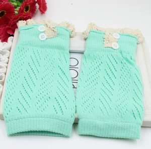 Dettaglio degli scaldamuscoli in maglia verde menta con pizzo e due bottoni decorativi