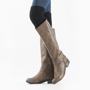 Detail of black knit leg warmers paired with dark brown knee-high boots and blue jeans
