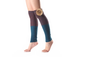Detail of two-tone knit leg warmers in burgundy and teal with fluffy pom-pom detail