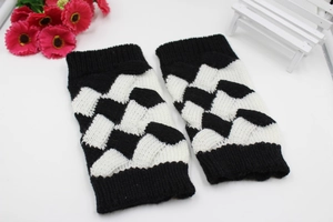Detail of black and white knitted fingerless gloves with textured checkered weave pattern