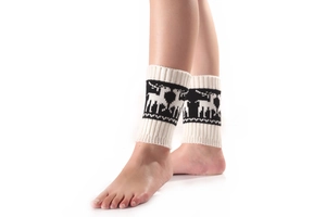 Gros plan sur des jambières en tricot blanc avec renne de Noël et motifs géométriques