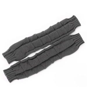 Close-up of dark grey knitted leg warmers with ribbed texture and segmented bubble design