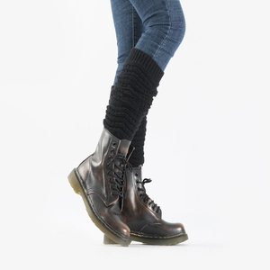 Close-up of black knitted leg warmers with ribbed cuffs styled over black leather boots