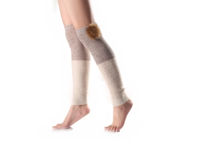 Detailed knit texture and fluffy fur pompom on ribbed bicolor knee-high leg warmers