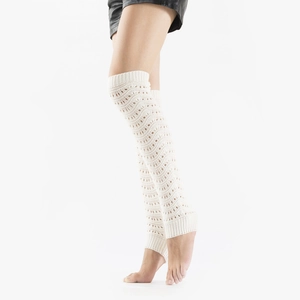 Detail of white knit leg warmers showing intricate hollow diamond weave pattern