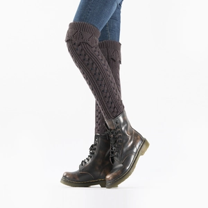 Detail of dark brown knit leg warmers with hollow mesh patterns and cable textures