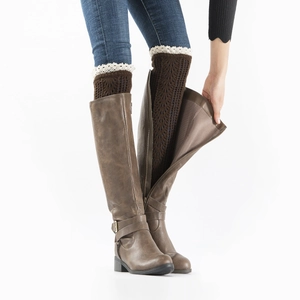 Close-up of brown cable knit leg warmers featuring delicate white lace trim detail