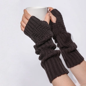 Detail von dunkelbraunen Strickstulpen mit Daumenloch und Zopfmuster an einer Tasse