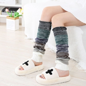 Détail de jambières en maille rayée multicolore et chaussons en peluche blancs pour l'hiver