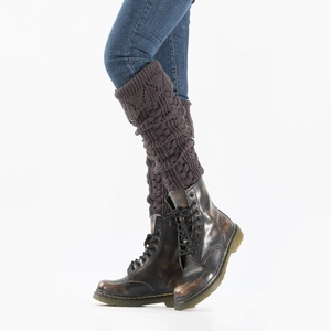 Close-up of dark brown cable knit leg warmers worn with boots and denim jeans