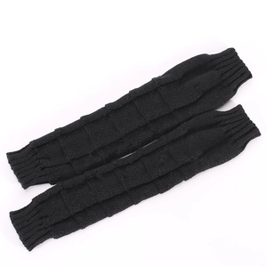 Close-up of black cable knit arm warmers with textured checkerboard pattern and ribbed cuffs